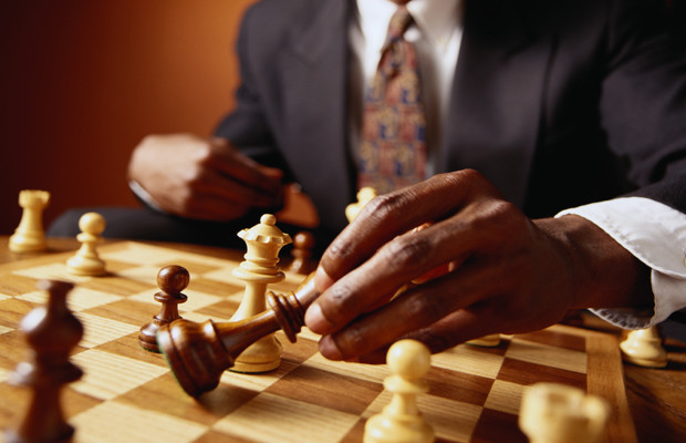 Businessman Moving a Chess Piece